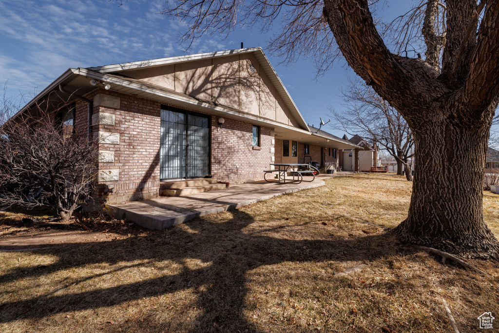 View of home\\\'s exterior with a yard and a patio area