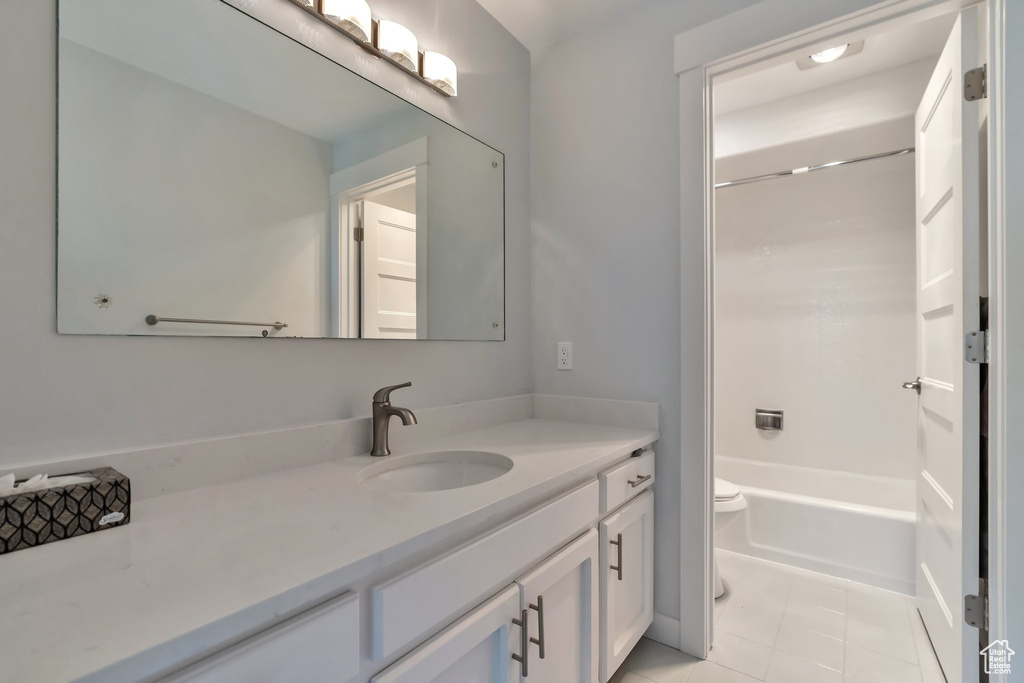 Full bathroom with vanity, toilet, tile flooring, and shower / bathing tub combination