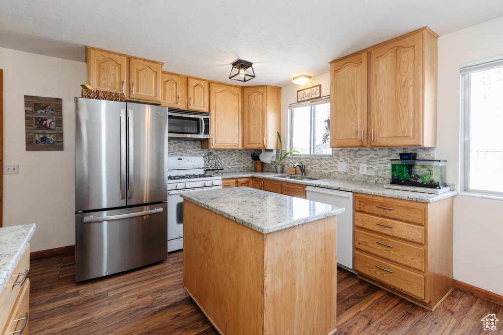 Kitchen featuring a center island, dark hardwood / wood-style flooring, stainless steel appliances, and backsplash