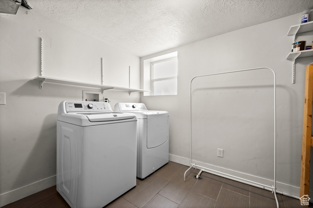 Washroom featuring washer and clothes dryer, a textured ceiling, and washer hookup