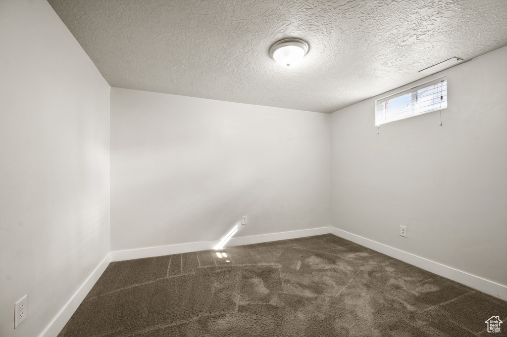 Carpeted empty room with a textured ceiling