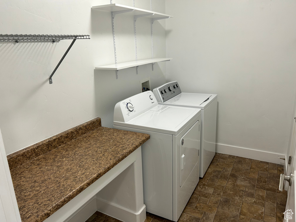 Clothes washing area with independent washer and dryer, hookup for a washing machine, and dark tile flooring