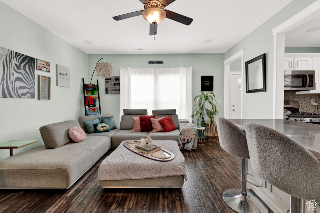 Living room featuring ceiling fan and dark hardwood / wood-style floors