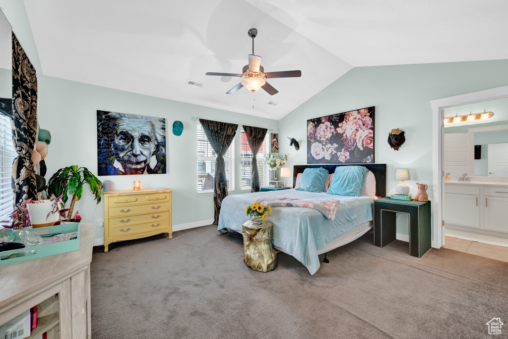 Bedroom featuring carpet floors, vaulted ceiling, ensuite bath, ceiling fan, and sink