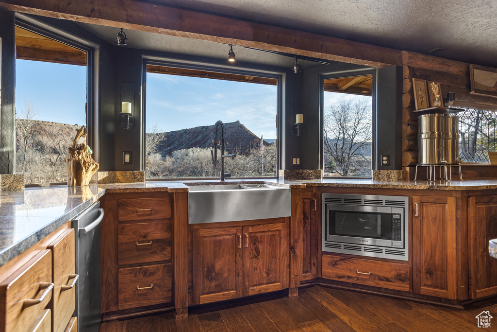 Kitchen with a textured ceiling, a mountain view, appliances with stainless steel finishes, dark hardwood / wood-style floors, and sink