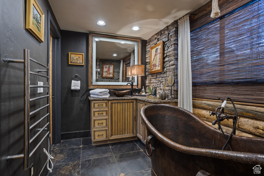 Bathroom with vanity, tile flooring, and a tub