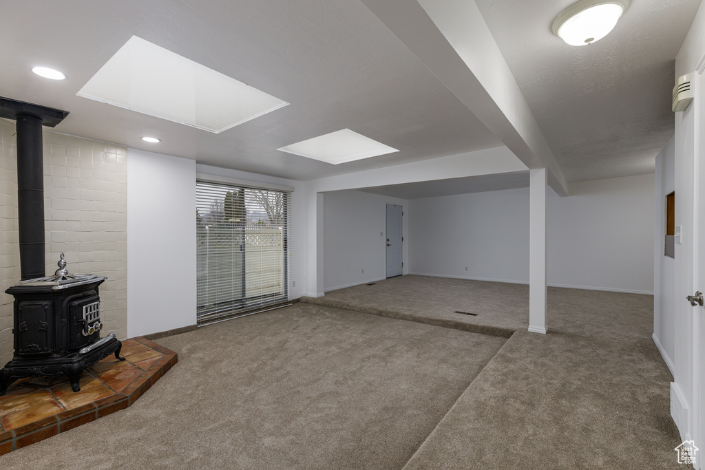 Basement with a wood stove and carpet