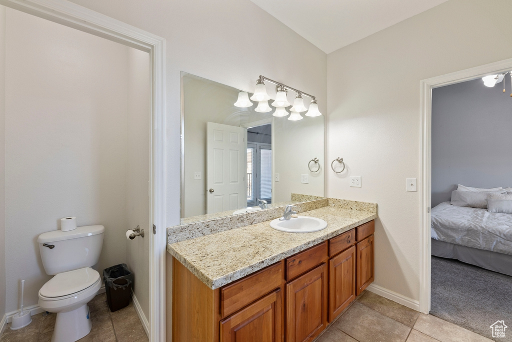 Bathroom with tile floors, large vanity, and toilet