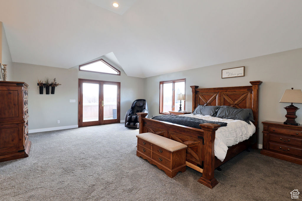 Bedroom with carpet floors, multiple windows, french doors, and lofted ceiling