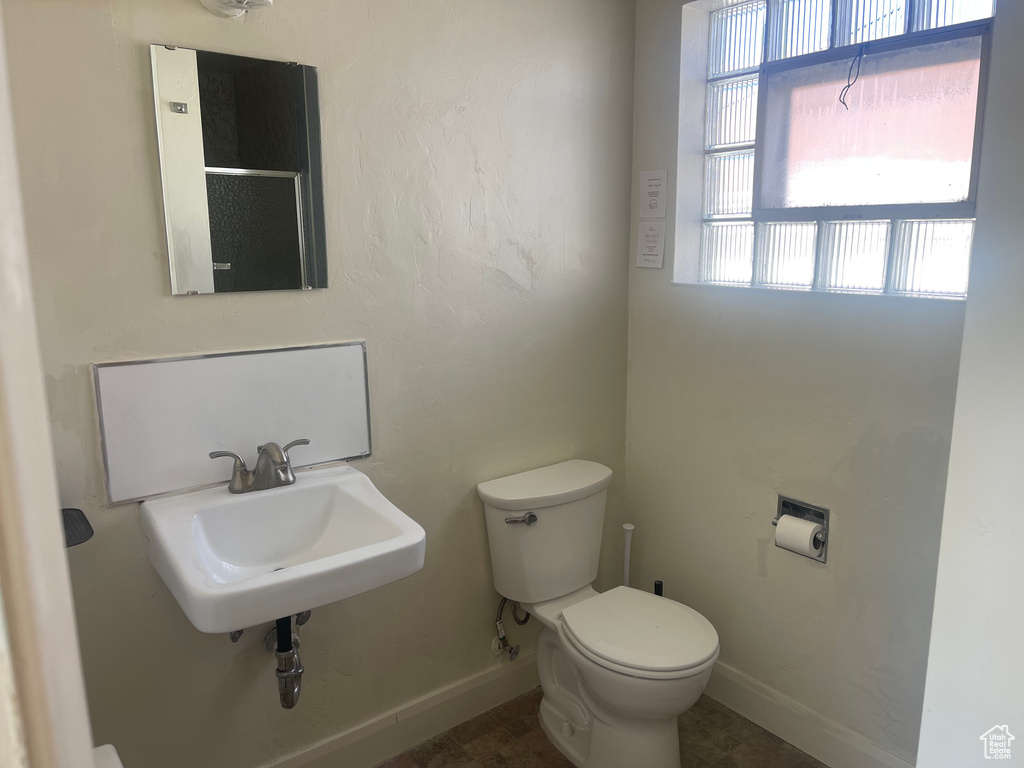 Bathroom featuring tile floors, a wealth of natural light, and toilet