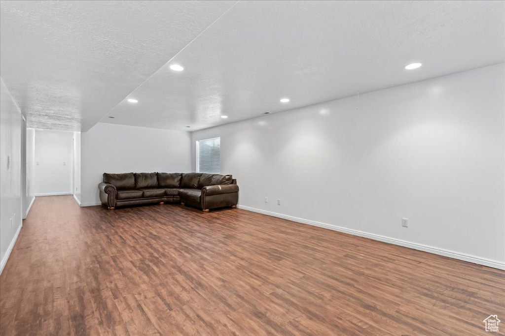 Living room with dark hardwood / wood-style flooring and a textured ceiling
