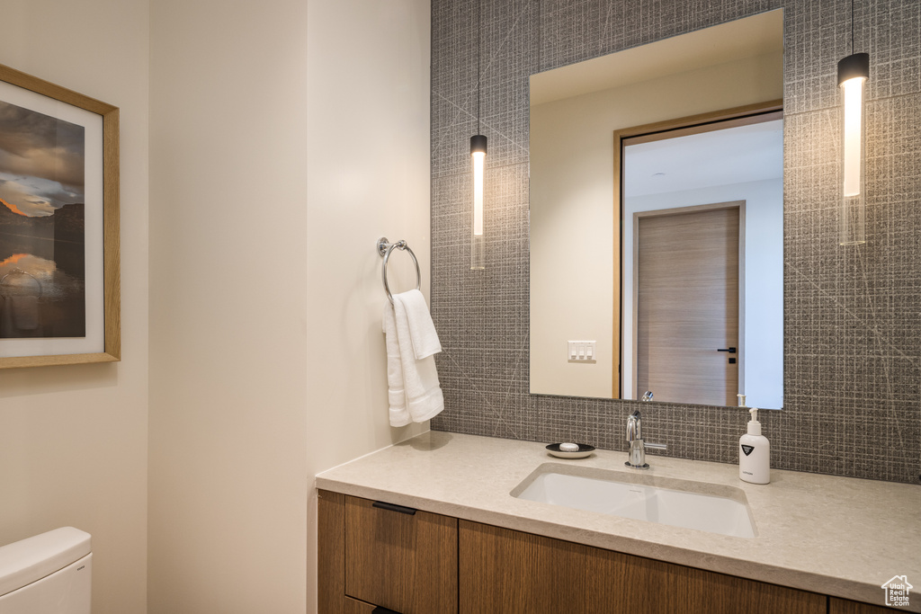 Bathroom featuring vanity and tasteful backsplash