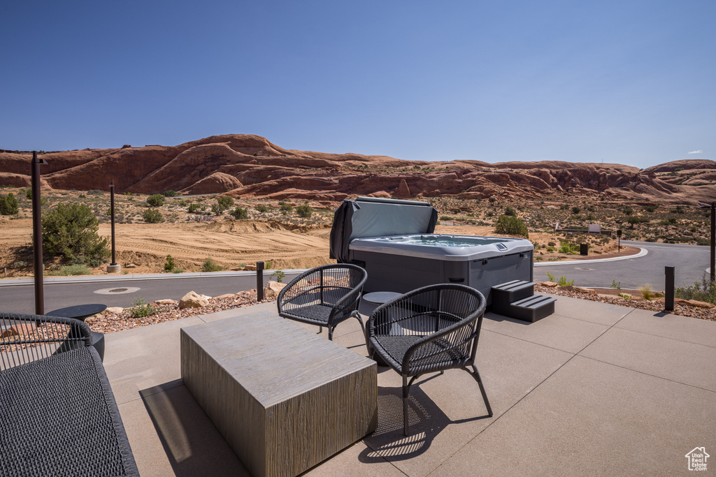 View of patio featuring a hot tub and a mountain view