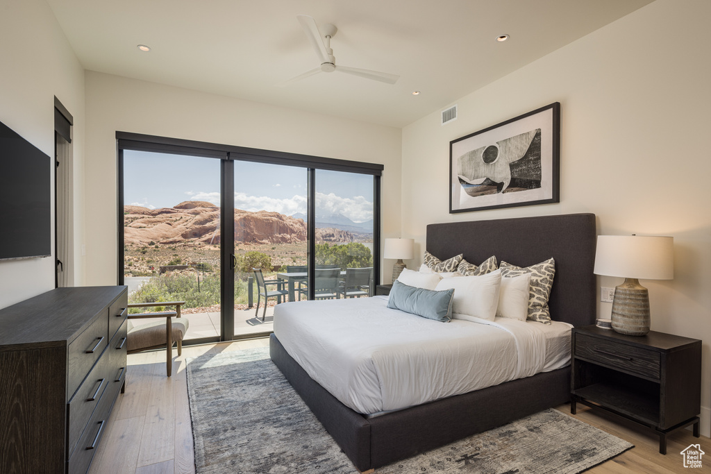 Bedroom with access to exterior, light wood finished floors, a mountain view, recessed lighting, and ceiling fan