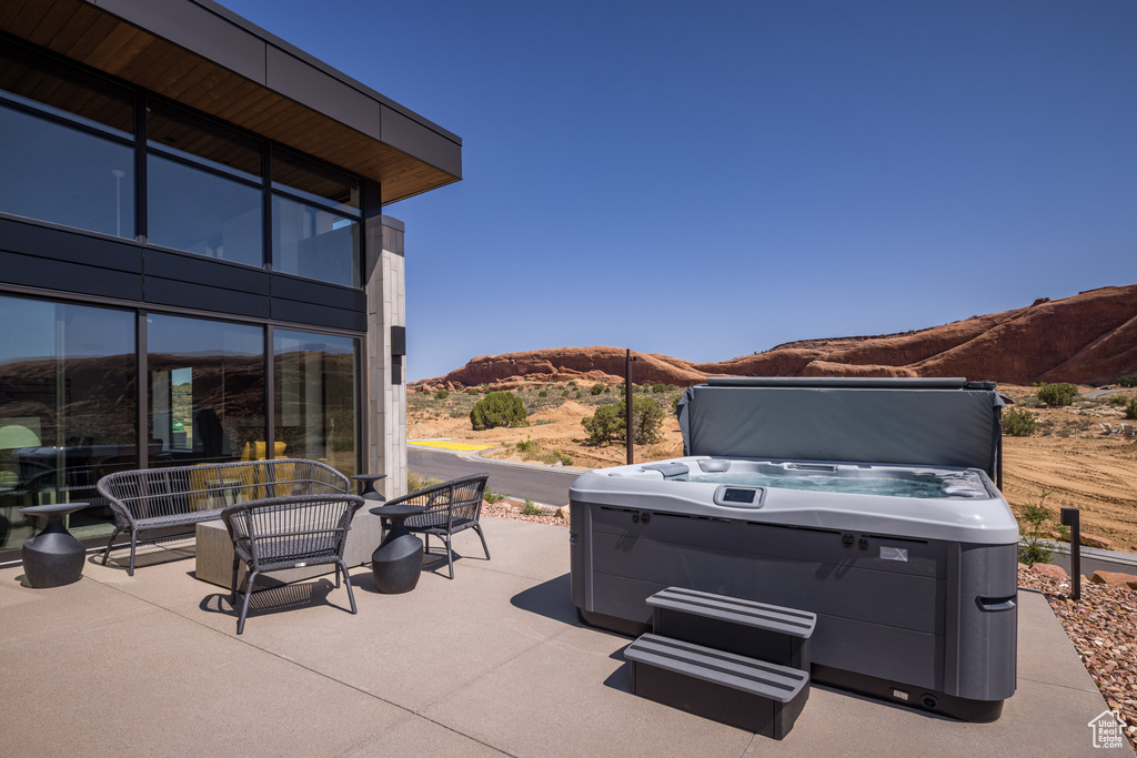 View of patio / terrace with a mountain view and a hot tub