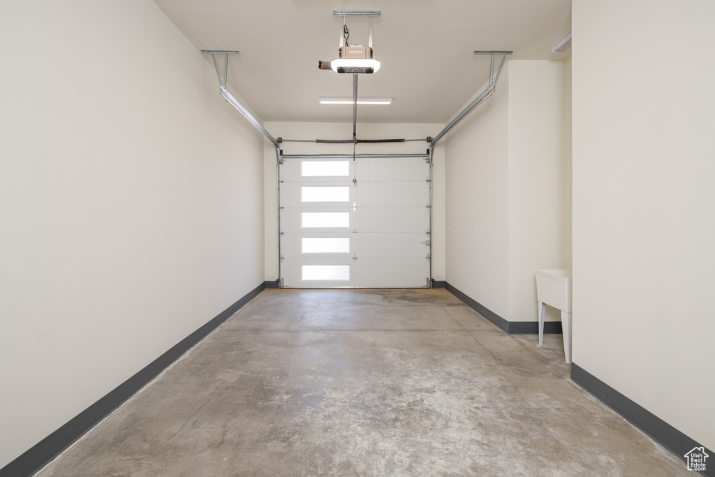 Garage with baseboards and a garage door opener