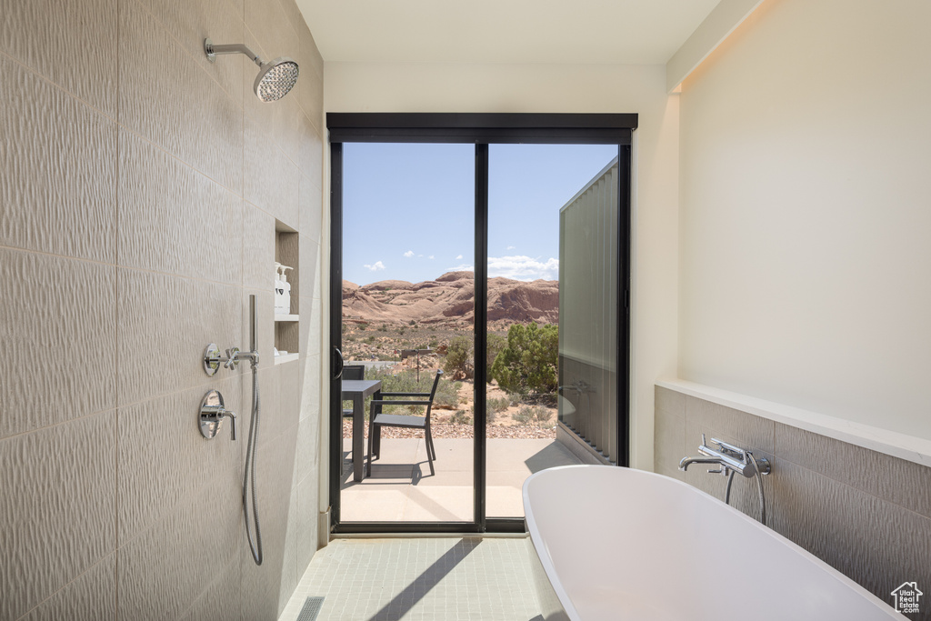 Full bath with a freestanding tub, tiled shower, and a mountain view