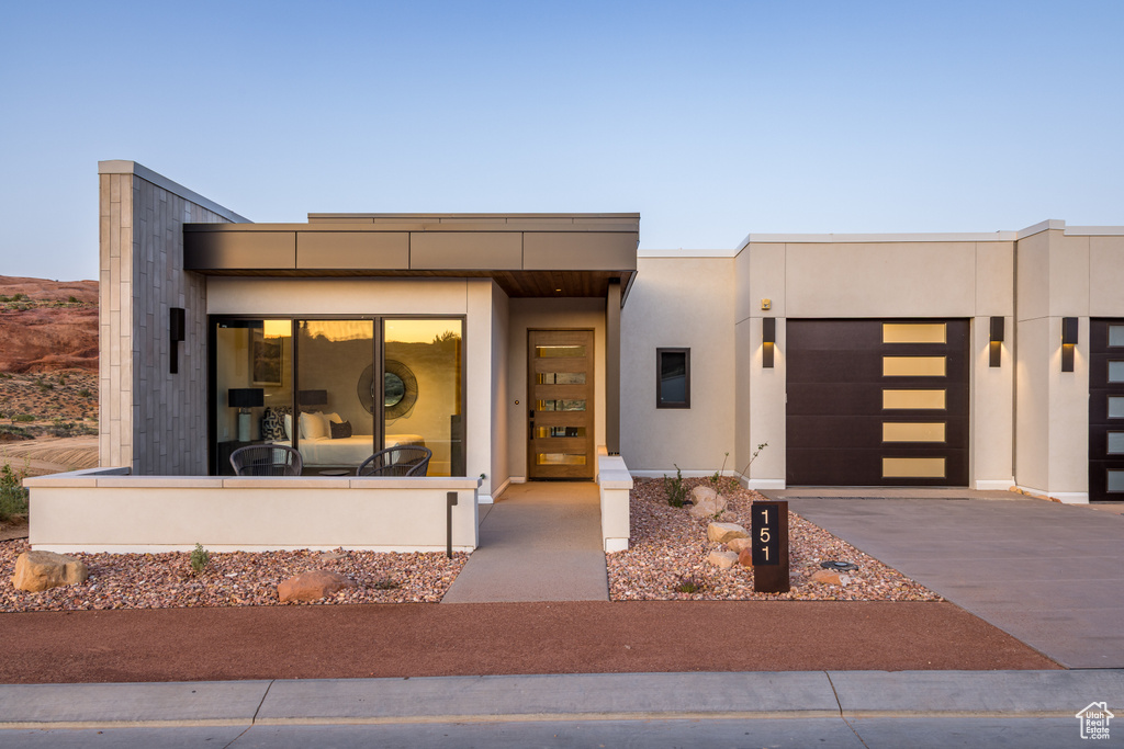 Modern home featuring driveway, a garage, and stucco siding