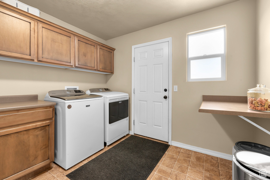Laundry area with light tile flooring, cabinets, separate washer and dryer, and hookup for a washing machine