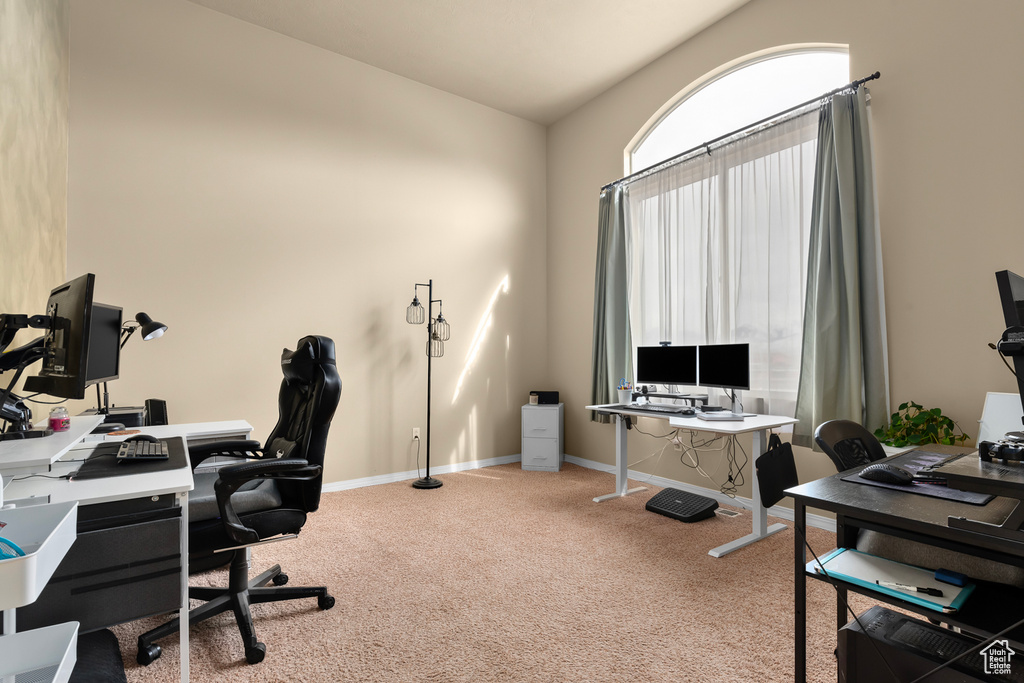 Office space with light colored carpet and lofted ceiling