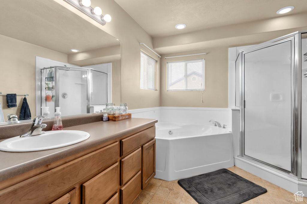 Bathroom with tile flooring, plus walk in shower, and vanity with extensive cabinet space