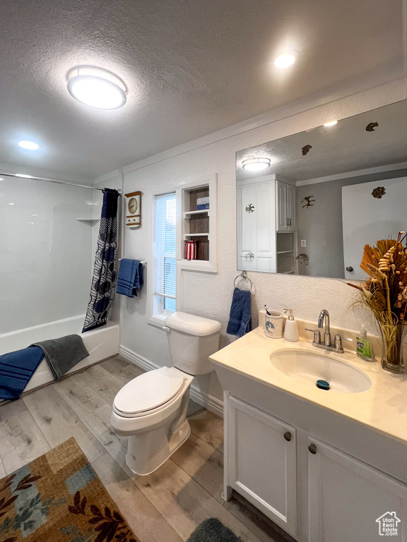 Bathroom featuring vanity, toilet, a textured ceiling, and wood-type flooring