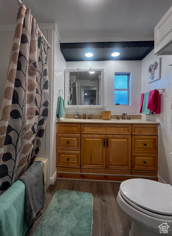 Bathroom featuring vanity, toilet, a textured ceiling, and hardwood / wood-style floors