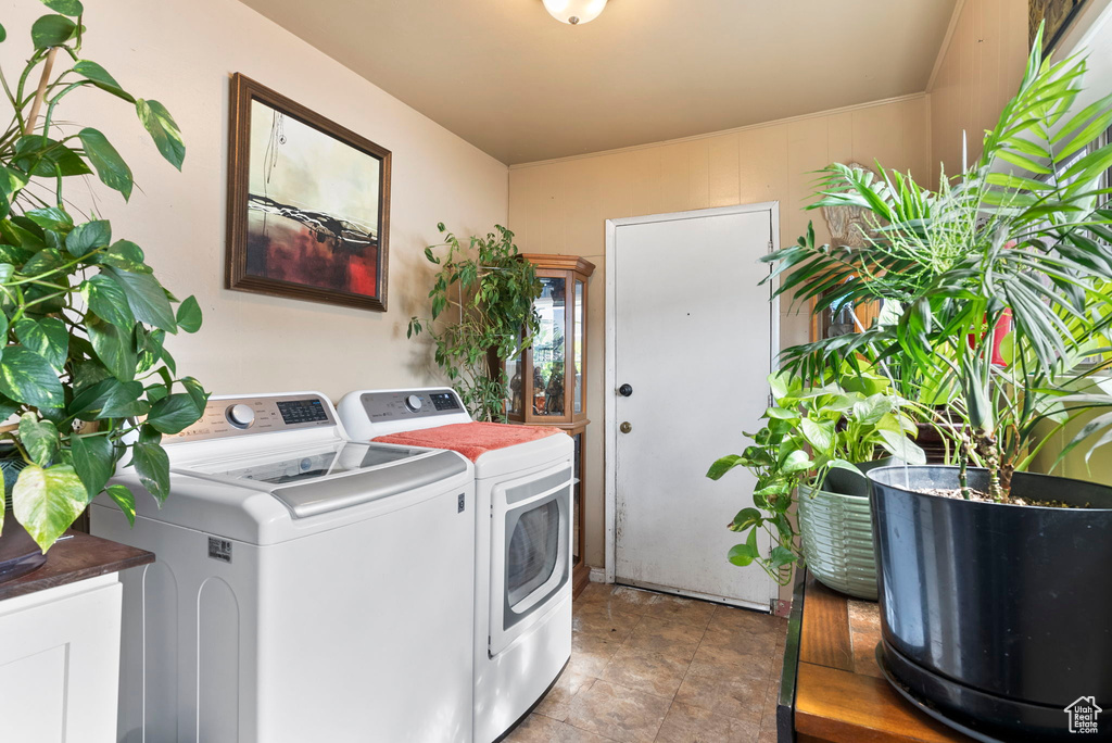 Laundry room with washer and clothes dryer and tile floors