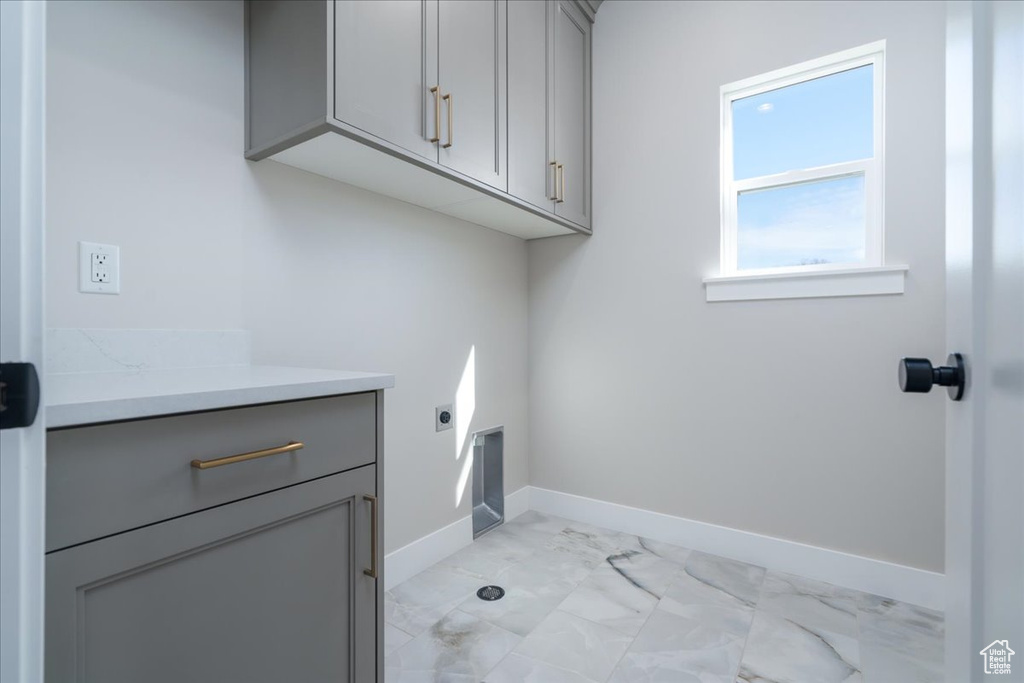 Washroom with cabinets, light tile floors, and hookup for an electric dryer