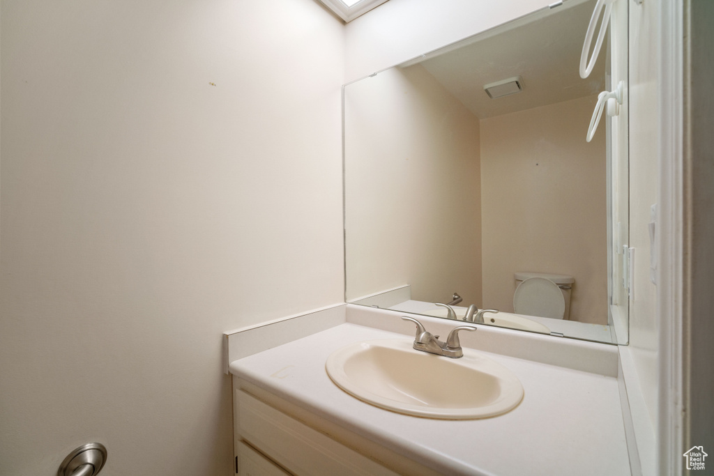 Bathroom with vanity, toilet, and a skylight