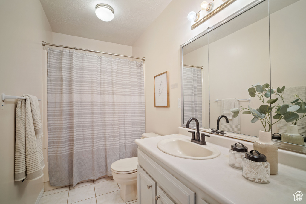 Full bathroom featuring tile floors, shower / tub combo with curtain, toilet, and oversized vanity