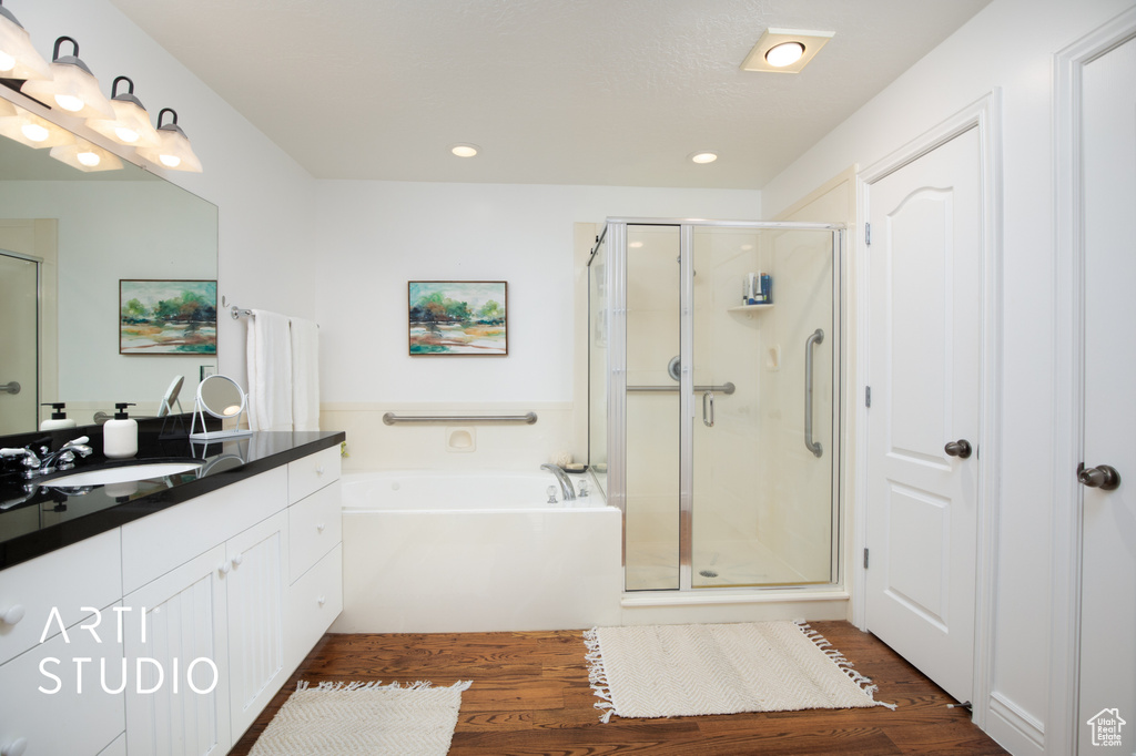 Bathroom featuring vanity, independent shower and bath, and hardwood / wood-style floors