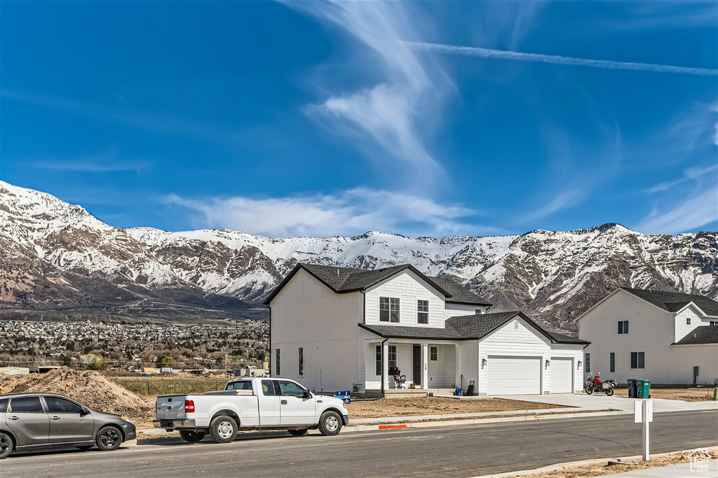 View of front of property with a mountain view and a garage