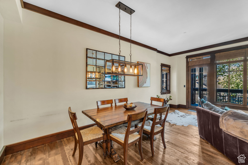 Dining area with an inviting chandelier, crown molding, and hardwood / wood-style floors