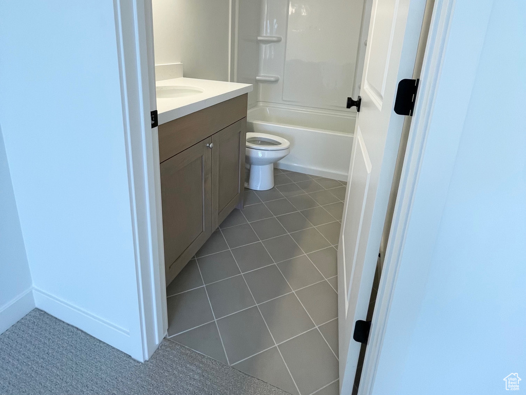Full bathroom with a textured ceiling, shower / washtub combination, tile floors, toilet, and vanity
