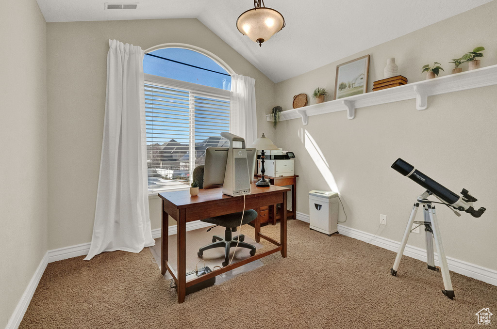 Office area with light colored carpet and lofted ceiling
