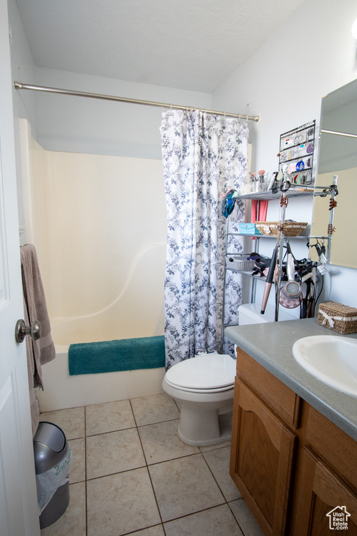 Full bathroom with vanity, toilet, shower / bath combination with curtain, and tile flooring