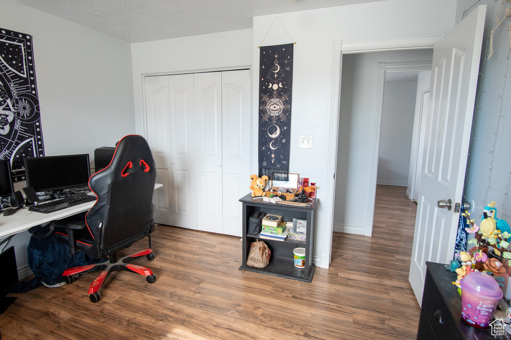 Home office with dark hardwood / wood-style flooring
