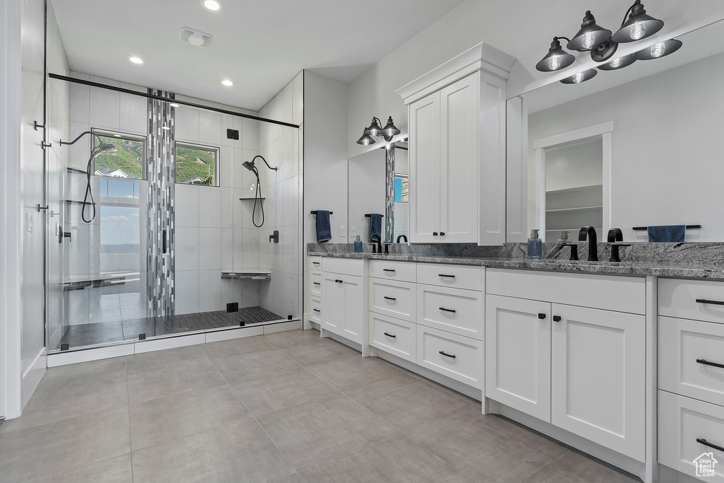 Bathroom with dual vanity, tile flooring, and walk in shower