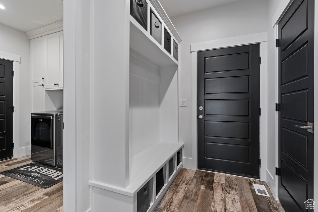 Mudroom with dark wood-type flooring and washer and dryer