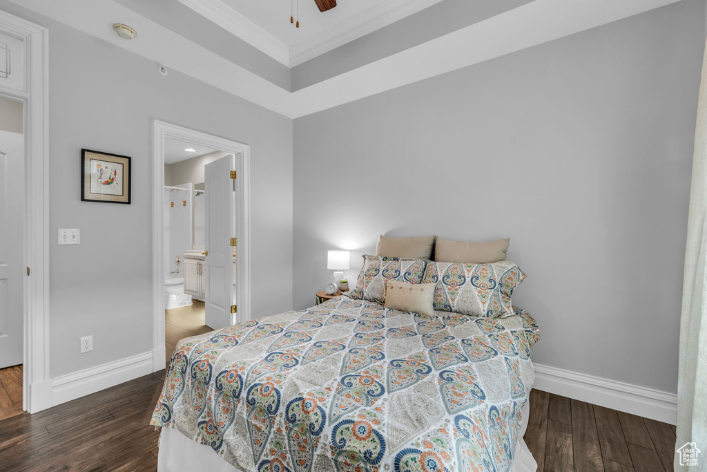 Bedroom with crown molding, dark wood-type flooring, ensuite bathroom, and ceiling fan