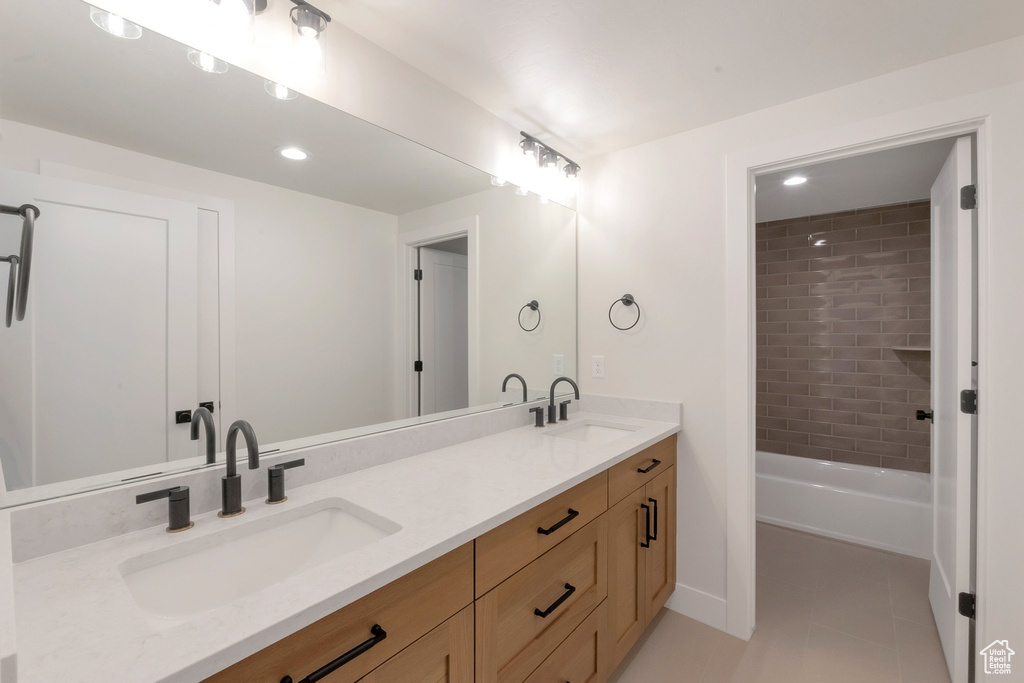 Bathroom with double vanity, tile floors, and tiled shower / bath combo