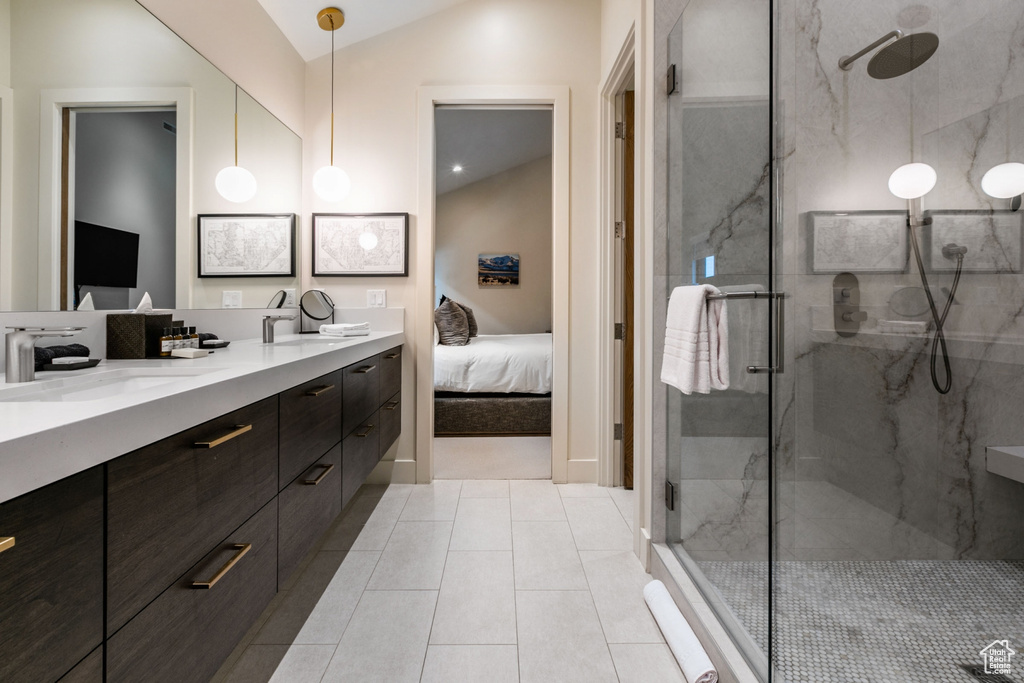 Bathroom featuring dual bowl vanity, walk in shower, lofted ceiling, and tile floors