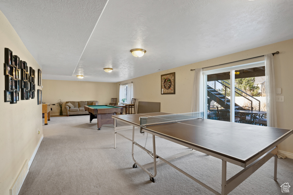 Game room featuring a textured ceiling, light carpet, and pool table