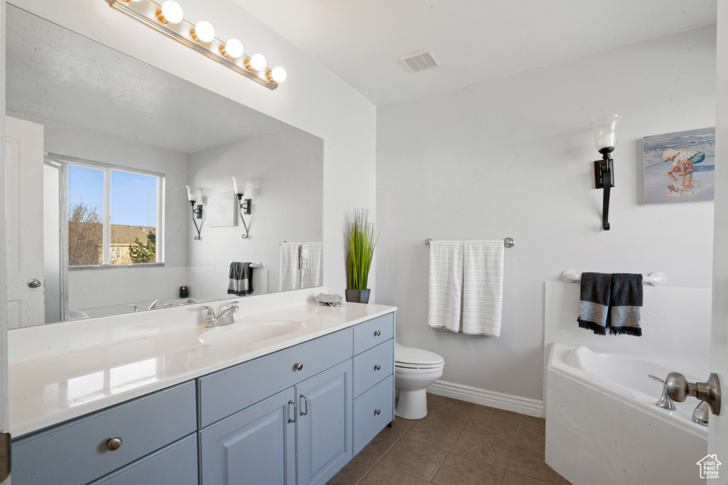 Bathroom with a washtub, tile floors, toilet, and vanity