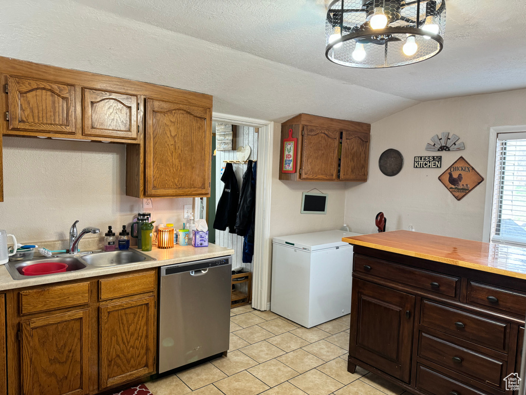 Kitchen featuring fridge, lofted ceiling, a notable chandelier, light tile floors, and dishwasher