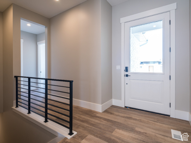 Entrance foyer featuring hardwood / wood-style flooring and a healthy amount of sunlight
