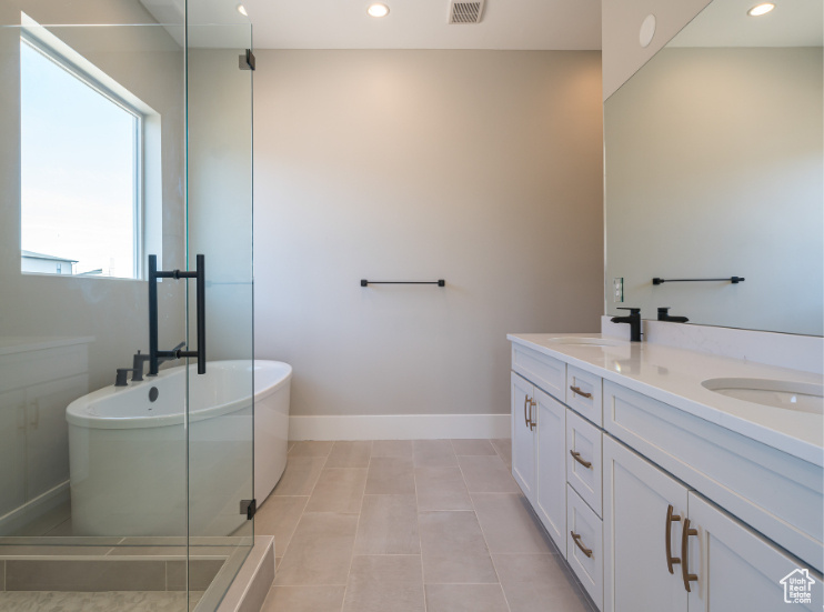 Bathroom featuring tile flooring, separate shower and tub, and double sink vanity