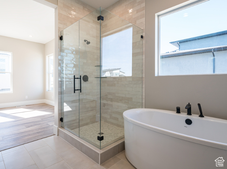Bathroom featuring tile flooring and shower with separate bathtub