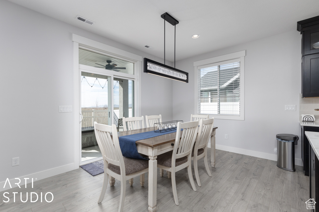 Dining space with light hardwood / wood-style floors and ceiling fan